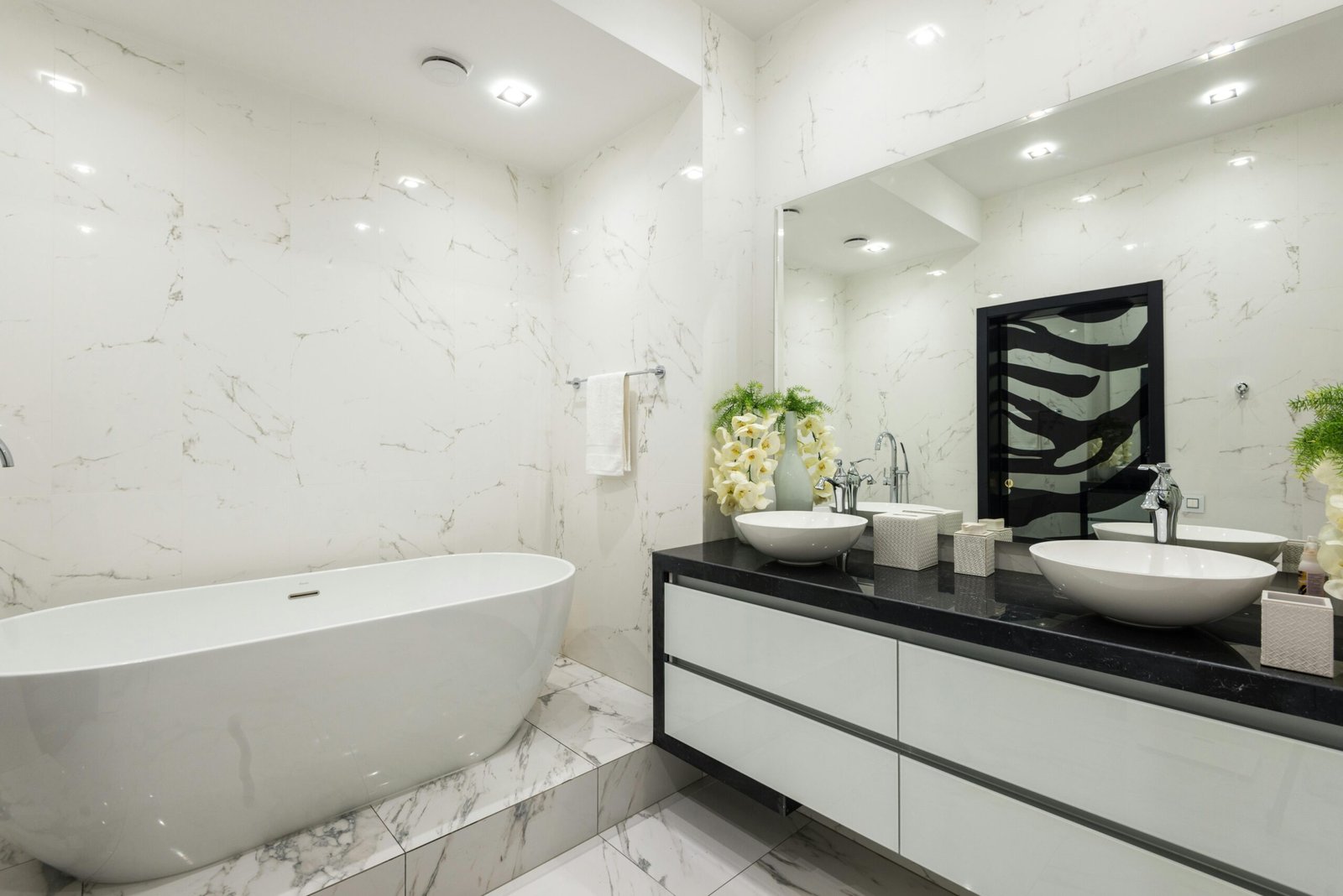 This high-end bathroom design includes a double vanity, marble backsplash, and under-cabinet lighting. With thoughtful layout design and luxurious finishes, this space feels custom-built for comfort and beauty. A top choice for those exploring bathroom designs that impress.