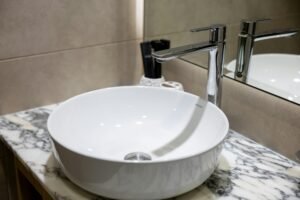 Bathroom Design 9 Elegant and timeless bathroom design with a standalone soaking tub, chandelier, and arched window detail. Every element is chosen to reflect timeless bathroom design with a hint of luxury. A standout choice for classic yet functional remodeling projects.