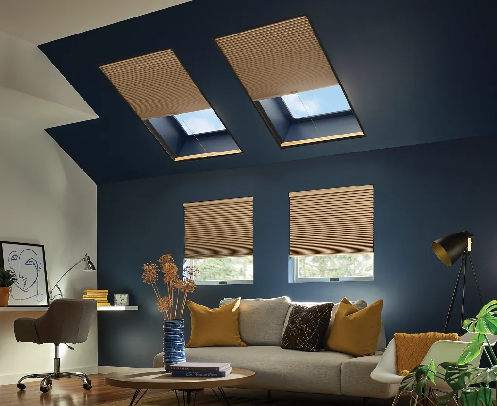 Warm-toned Graber custom blinds cover skylights and windows in a cozy, modern living room. These custom window treatments filter natural light beautifully, blending effortlessly with the deep navy ceiling and neutral decor for a comfortable, inviting space.