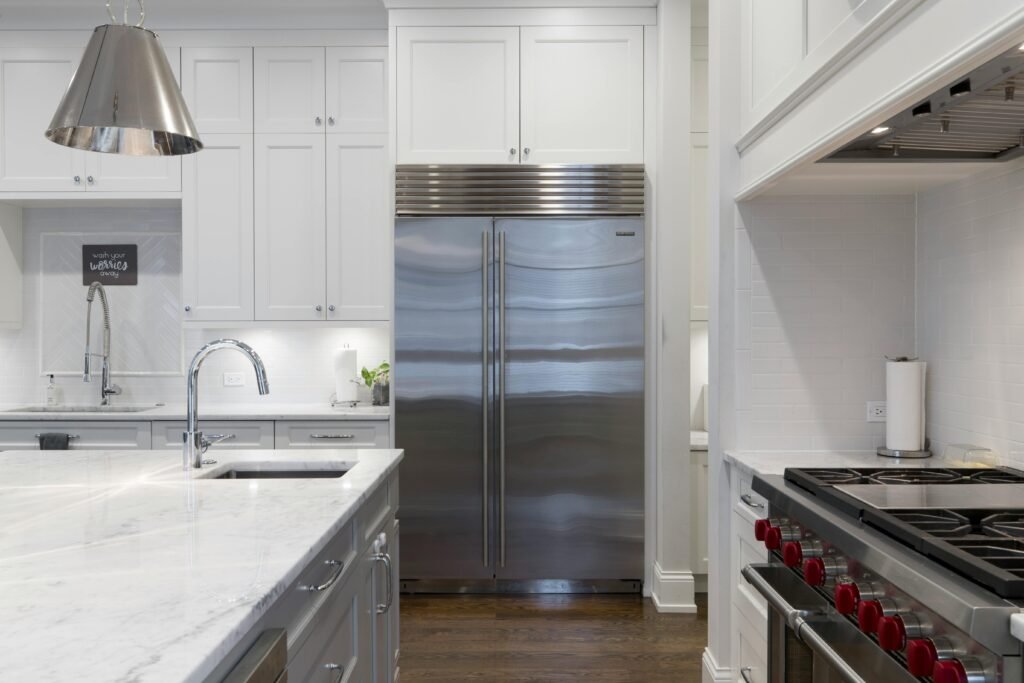 kitchen-design-trends Bright kitchen interior with gray backsplash tile, pendant lighting, and a large island with bar seating - blending functional space planning with stylish interior design elements.