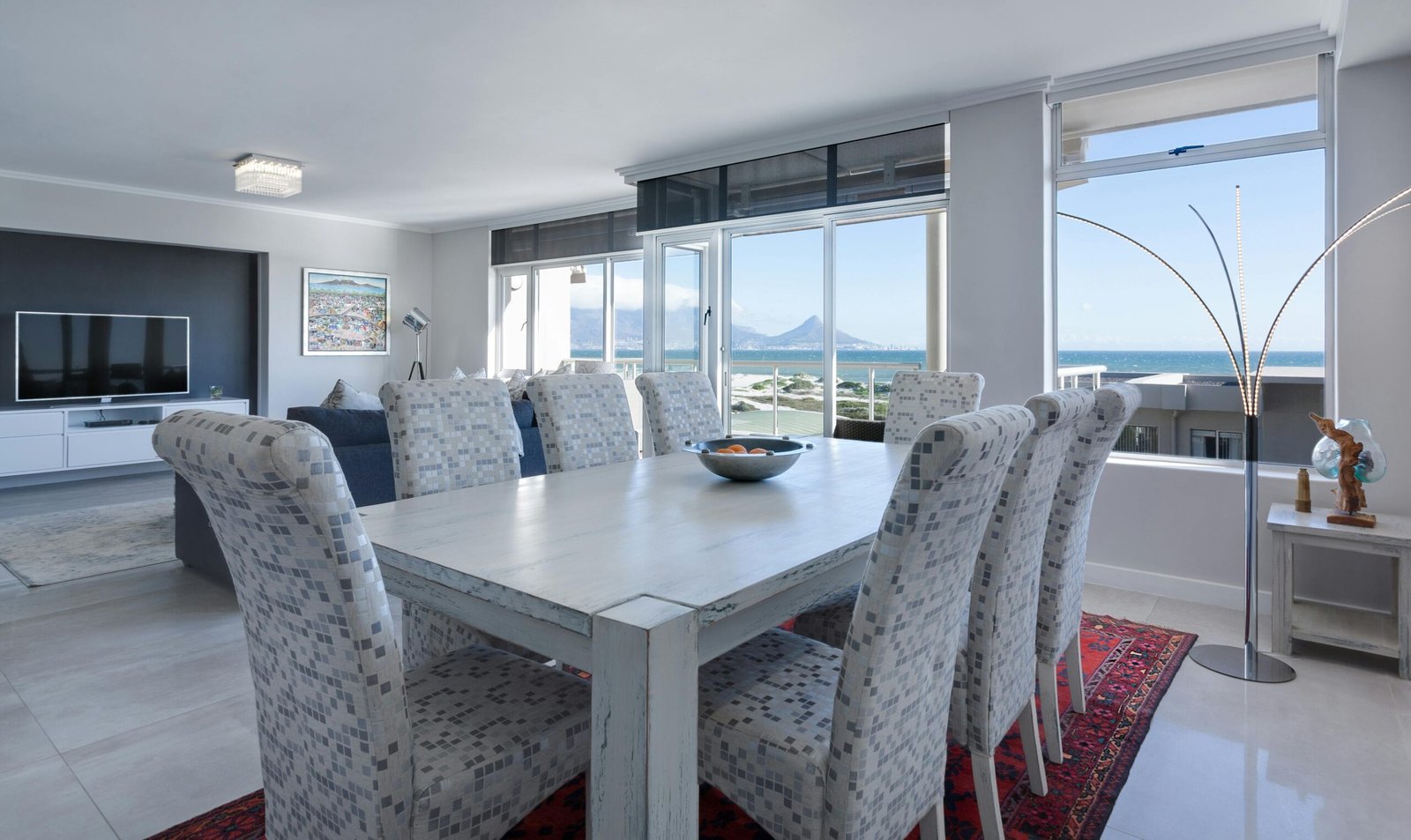 Layered window treatments bring texture and dimension to this bright, modern dining space. These custom window coverings soften the room’s edges while still letting natural light shine through.