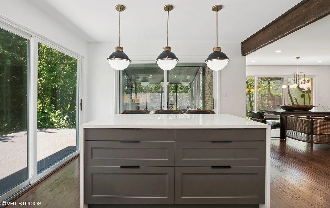 Close-up of kitchen island in a Flossmoor home, featuring soft pendant lighting, wide drawers, and a smooth quartz surface.