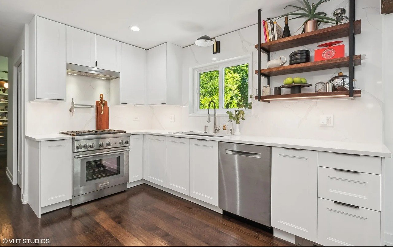 Finished Flossmoor kitchen showing slab quartz backsplash extending to ceiling behind open shelving and vent hood.